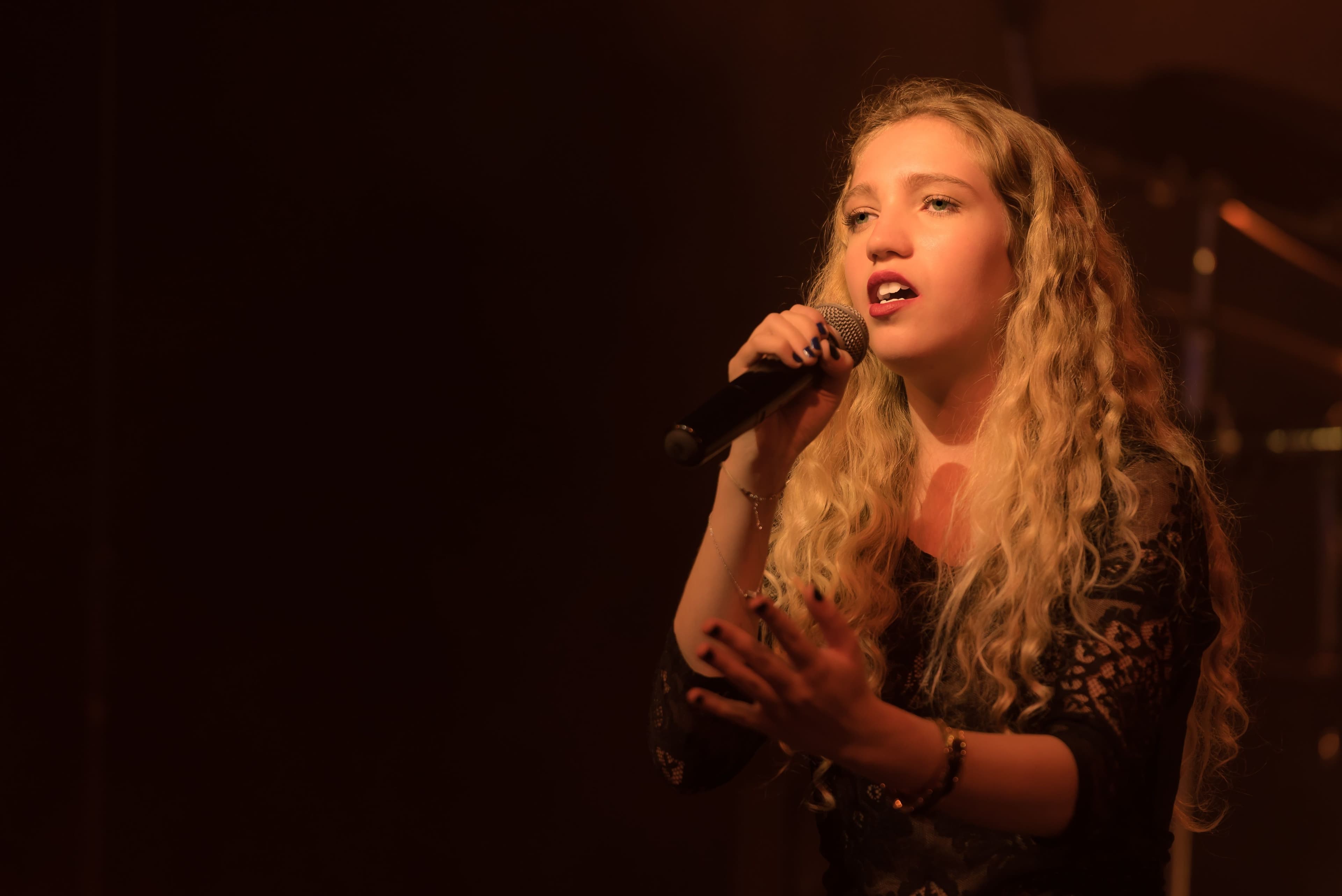 Chanteuse au micro pour une intervention vocale sur mesure à Paris, dans le 92 et en visio